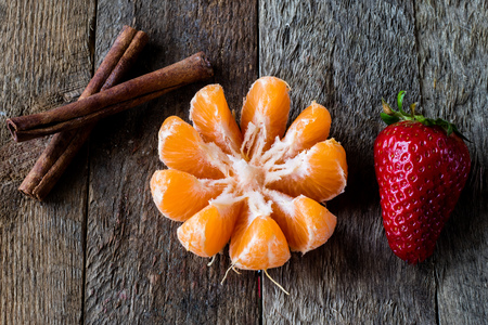 Strawberries and tangerines on an old wooden table in an old kitchen, black backgroundの写真素材