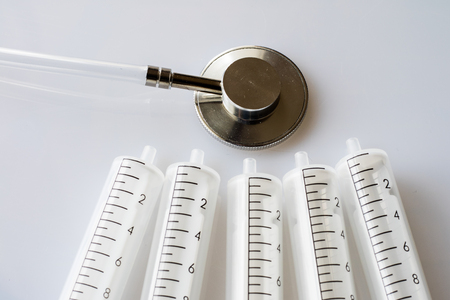 syringes and stethoscope on a withe backgroundの写真素材