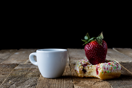 Coffee in a cup with a sweet dessert on an old table, black backgroundの写真素材