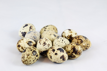 Quail eggs on a white isolated background in a mold on a jute napkinの写真素材