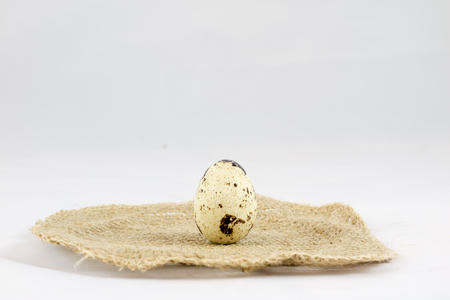 Quail eggs on a white isolated background in a mold on a jute napkinの写真素材