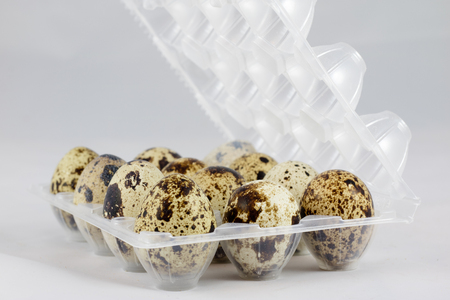 Quail eggs on a white isolated background in a mold on a jute napkinの写真素材