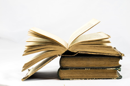 Old dusty book and sheet of paper on white isolated backgroundの写真素材