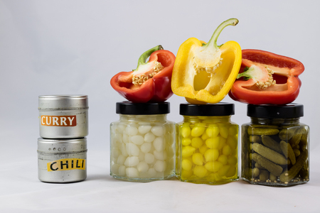 Red and yellow peppers, preserves and olive oil in the pantryの写真素材