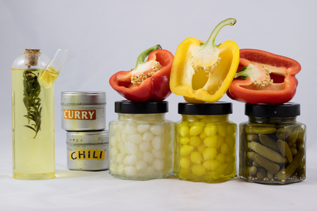 Red and yellow peppers, preserves and olive oil in the pantryの写真素材