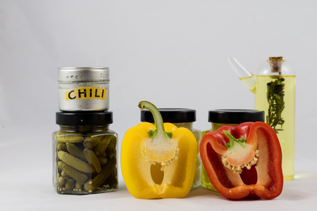 Red and yellow peppers, preserves and olive oil in the pantryの写真素材