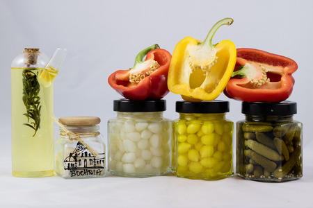 Red and yellow peppers, preserves and olive oil in the pantryの写真素材