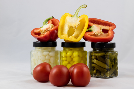 Red and yellow peppers, preserves and olive oil in the pantryの写真素材