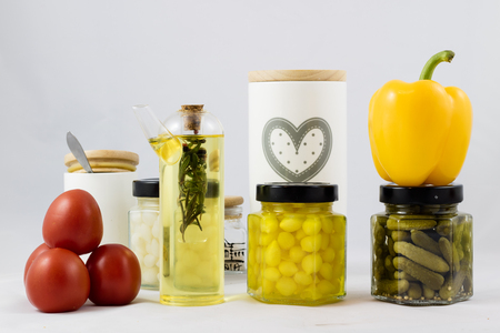Red and yellow peppers, preserves and olive oil in the pantryの写真素材