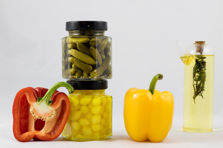 Red and yellow peppers, preserves and olive oil in the pantryの写真素材