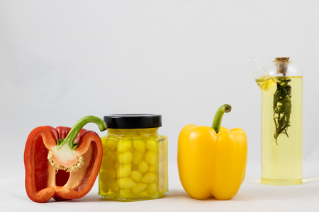 Red and yellow peppers, preserves and olive oil in the pantryの写真素材