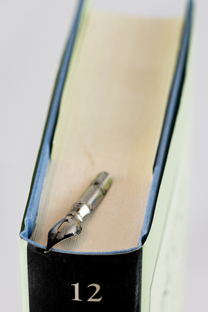 Heap of books on a white isolated background with a nibの写真素材