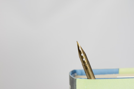 Heap of books on a white isolated background with a nibの写真素材