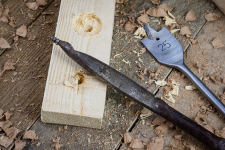 Old carpentry, carpentry workshop, drilling in a piece of wood.