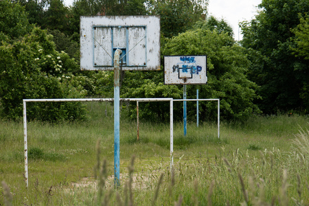 Old basketball court, basket, snatched netting against the sky and cloudsの写真素材