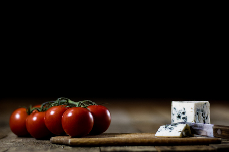 Tasty country bread and olive oil in a glass bottle. Black background and wooden table.の写真素材