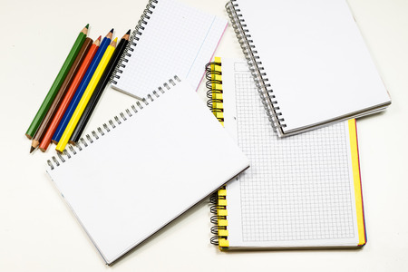 Sketchbook and crayons on a white table. White table and white background