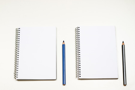 Sketchbook and crayons on a white table. White table and white backgroundの写真素材
