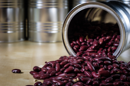 Delicious beans in a metal jar on a wooden kitchen table. Black background.の写真素材
