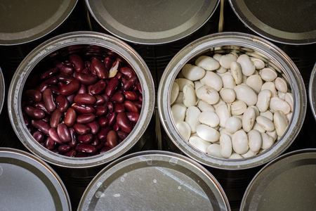 Delicious beans in a metal jar on a wooden kitchen table. Black background.の写真素材