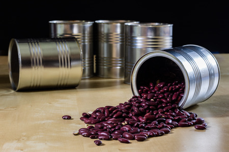 Delicious beans in a metal jar on a wooden kitchen table. Black background.の写真素材