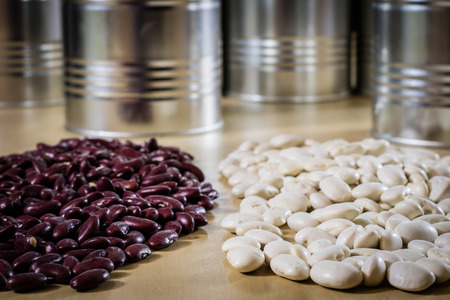 Delicious beans in a metal jar on a wooden kitchen table. Black background.の写真素材