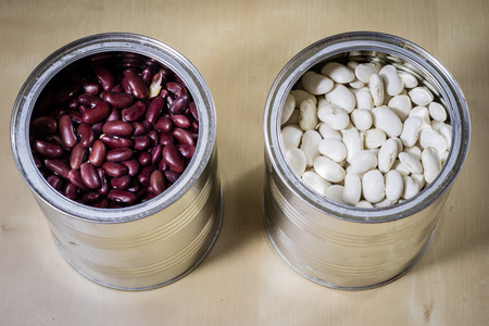 Delicious beans in a metal jar on a wooden kitchen table. Black background.の写真素材