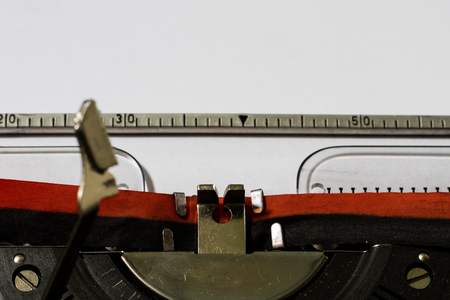 Typewriter with a blank white paper. Writing on typewriter. Black background.の写真素材