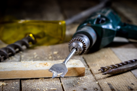 Old good carpentry, tools drill bit. Wooden carpentry table and old good carpentry tools on it. Black background.の写真素材