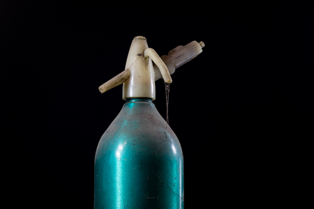 Old dusty siphon on black background. The cobwebs entwining the old siphon into soda water. Black background.の写真素材