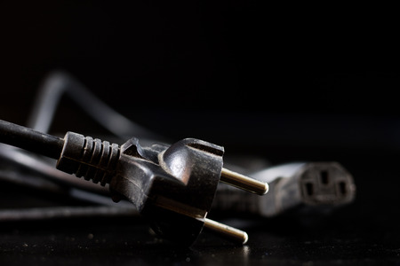 Old entangled cables, electronics and old cable connectors on a black table. Black backgroundの写真素材