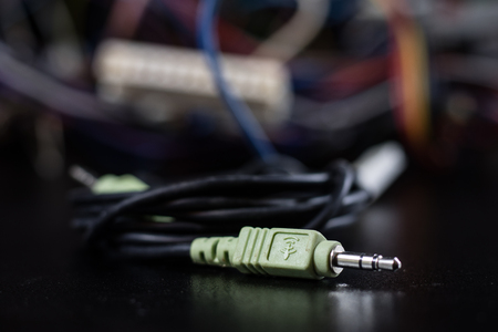 Old entangled cables, electronics and old cable connectors on a black table. Black backgroundの写真素材