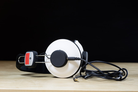 headphones for listening to music. Old good music from the 80s. Wooden table and black backgroundの写真素材