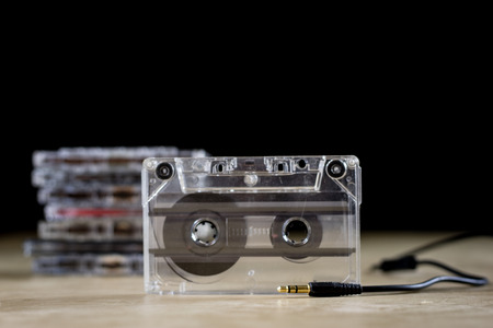 Cassette tape on a wooden table. Old good music from the 80's. Black backgroundの写真素材