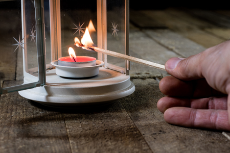 Two small lanterns on a wooden table. Candle in old latarence. Wooden table. Black background.