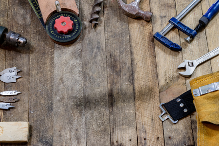 Tools on a wooden table in an old workshop. Arranged on the edge of the table. wooden table, black background.の写真素材