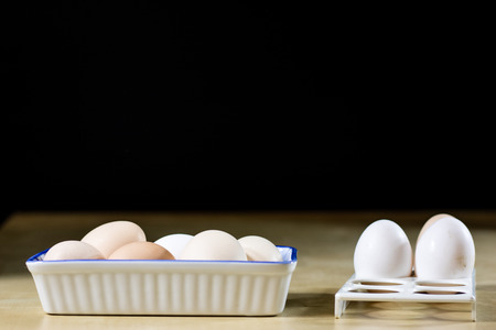 Egg, milk and jug on the kitchen table. Kitchen table with food products. Black background.