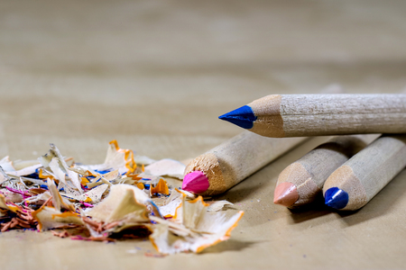 crayons and pencil sharpener on a wooden office table. Crayons with sharpening crayons and pencils on the table next to colored pencils. black background.の写真素材