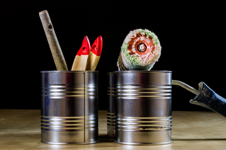 Old paintbrushes for paint, Cans of paint on wooden table. Painting workshop. Black backgroundの写真素材