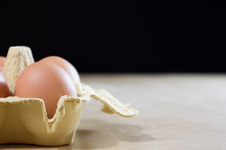 Eggs in molds on a wooden kitchen table. Hen egg in the kitchen atmosphere. black background