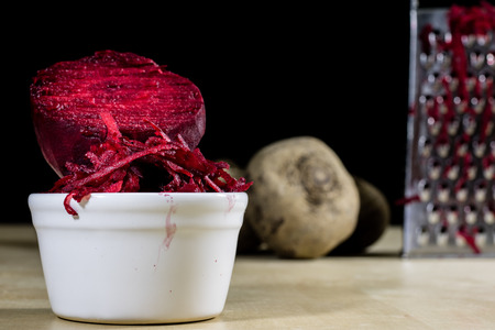 Beetroots grated on shavings. Wooden dining table. Black background.の写真素材