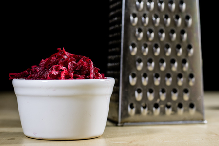 Beetroots grated on shavings. Wooden dining table. Black background.の写真素材