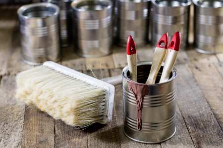 Cans of paint and brush on a wooden table. Painting with brushes.の写真素材