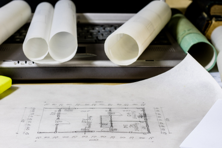 architect's table, laptop, calculator on the table. Plans, projects and notepad on the architect's...