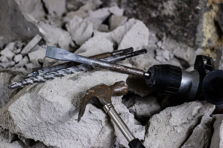 Demolition of walls. Electric hammer helmet and hearing protection lying on the rubble. Old brick and remodeled building wall. Grunt on the background of the old wall.の写真素材