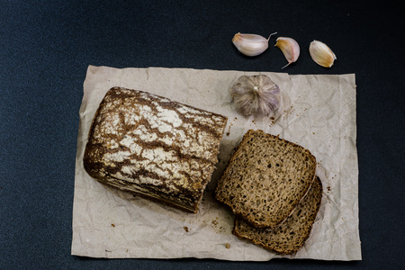 Black bread on gray paper. Spices and oil next to slices of bread. black backgroundの写真素材