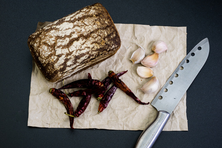 Black bread on gray paper. Spices and oil next to slices of bread. black backgroundの写真素材