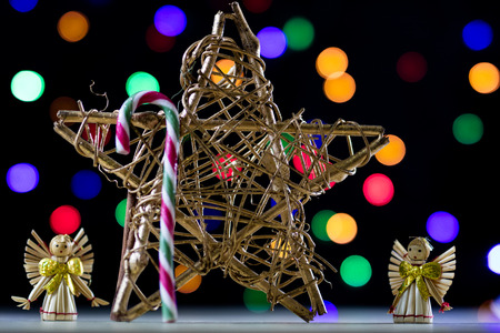 A celebratory Christmas star on a wooden table. Christmas decorations on the background of Christmas lights.Black backgroundの写真素材