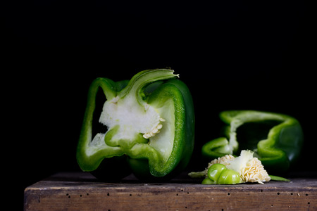 Chopped green paprika on an old kitchen table. Vegetables in the old kitchen. Black background.の写真素材