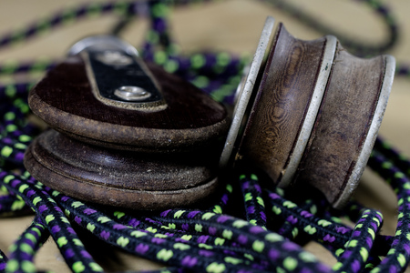 Rigging, sailing accessories. Rope block and shekel on a wooden table. Black backgroundの写真素材